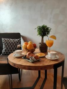 - une table en bois avec un plateau de fruits et des tasses à café dans l'établissement Urban Lodge Belgrade, à Belgrade