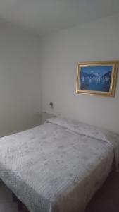 a bed in a room with a picture on the wall at Hotel Lory in Garda