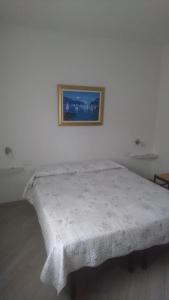 1 cama en una habitación con una foto en la pared en Hotel Lory, en Garda