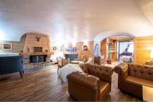 een woonkamer met een bank en een open haard bij Hotel La Montagne in La Clusaz