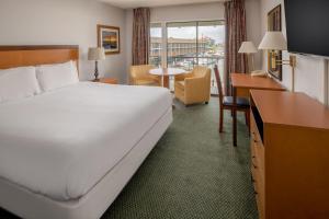 アストリアにあるAstoria Riverwalk Innの大きなベッドとデスクが備わるホテルルームです。