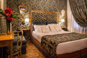 a bedroom with a bed and a table and a desk at Hotel Santo Stefano in Venice