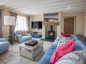 a living room with a blue couch and a fireplace at Penrhyn Barn in Penrhos-Lligwy
