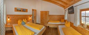 a room with two beds and a tv in it at Kama Alm in Aschau