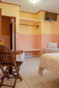a room with a bed and a chair and a table at Casa Palma Hotel in Playa del Carmen