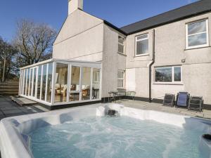 a house with a large swimming pool in front of a house at Glyn Ewryd in Bodewryd