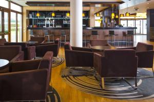 um restaurante com cadeiras e mesas e um bar em Holiday Inn Express London - Epsom Downs, an IHG Hotel em Epsom