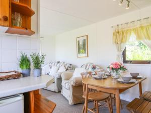 a kitchen and living room with a table and a couch at Castell Chalet in Pwllheli