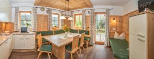 a kitchen and dining room with a table and chairs at Kama Alm in Aschau