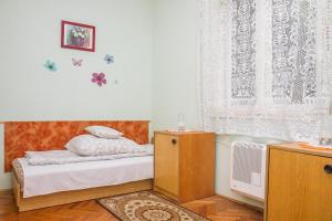 a small bedroom with a bed and a window at Familia Nyaraló 22 in Balatonmáriafürdő