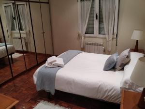een slaapkamer met een bed met een handdoek erop bij APARTAMENTO CENTRO GIJON Vut1703AS in Gijón