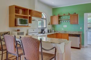 a kitchen with wooden cabinets and a counter top at Sunrise 18 in Tamarindo