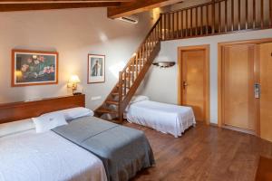 a bedroom with two beds and a staircase at Hotel Fonda Merce in Llivia