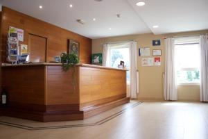 a bar in a room with wooden walls and windows at Hotel Parking Miradoiro de Belvís in Santiago de Compostela