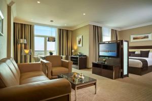 Großes Hotelzimmer mit einem Bett und einem TV in der Unterkunft Karbala Rayhaan Hotel & Suites in Karbala