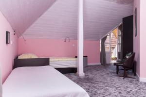 バラトンケレストゥールにあるFamilia Apartman 304のピンクの壁のベッドルーム(ベッド1台、椅子1脚付)