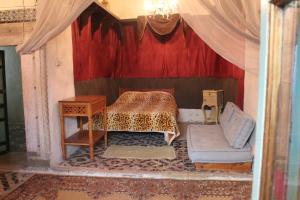 Habitación con cama, mesa y silla en Maison du 18ème Siècle, en Túnez