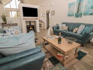 a living room with two blue couches and a table at Betony in Bamburgh