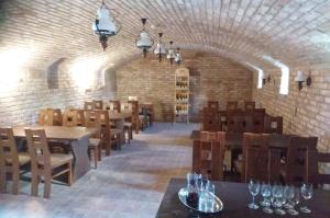 a restaurant with tables and chairs and a brick wall at Penzion Tramín in Valtice