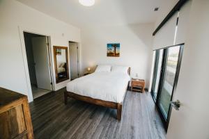 1 dormitorio con cama blanca y ventana grande en LXTX Luxury Apartments by Corporate Stays, en Winnipeg