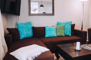 a living room with a brown couch with blue pillows at Landfein-Villa Marathon in Winterberg