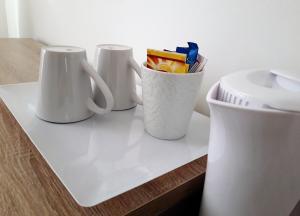 3 tasses à café blanches assises sur un comptoir dans l'établissement Les Hauts de Malirat, à Capdenac-Gare