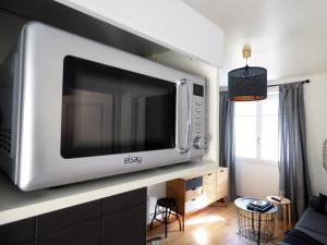 a microwave hanging on a wall in a living room at Les Hauts de Malirat in Capdenac-Gare