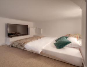 sypialnia z białym łóżkiem i telewizorem z płaskim ekranem w obiekcie Nasze Kamienice Apartament Muzyczny z antresolą w mieście Rzeszów