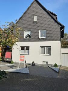 Uma casa branca com um cartaz à frente. em Ferienwohnung Lorenz em Oberhausen