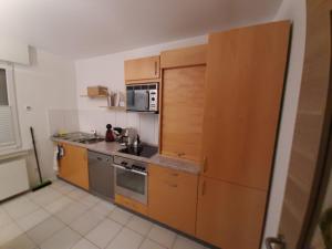 una pequeña cocina con armarios y electrodomésticos de madera en Ferienwohnung Lorenz en Oberhausen