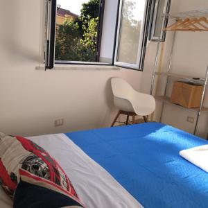 een slaapkamer met een bed, een stoel en een raam bij Palermo Central To Bed in Palermo