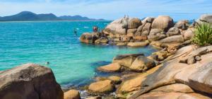 a group of people on rocks in the water at Apto Rua da Praia in Florianópolis