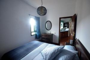 ein Schlafzimmer mit einem Bett und einem großen Spiegel in der Unterkunft Casa Caballería in Vallebrón