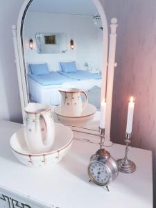 a room with a bed and a mirror and a clock at Höhällets Lantliga Rum in Värnamo +15 photos