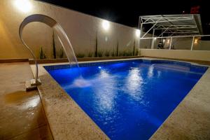 a swimming pool with a water fountain in a room at Pousada Recanto das Caldas in Caldas Novas