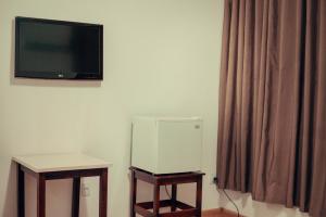 a room with a tv on the wall and a table at Hotel Obino in São Gabriel