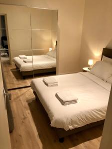 - une chambre avec 2 lits et un miroir dans l'établissement GH Apartment Pasteur-Montparnasse, à Paris