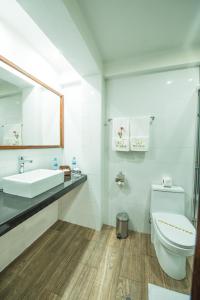 a white bathroom with a toilet and a sink at Posada San Blas in Cusco