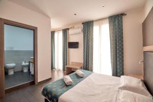 a hotel room with a bed and a bathroom at La Terrazza sul Centro in Palermo