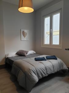 a bedroom with a large bed with a window at PISO LOFT MUY CÉNTRICO , a 50m de MARIA PITA y del puerto in A Coruña