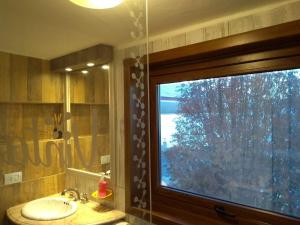 Vintage Bariloche Hostel Boutique في سان كارلوس دي باريلوتشي: حمام مع حوض ونافذة كبيرة +21 صورة