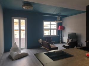 uma sala de estar com paredes azuis e uma mesa e cadeiras em PISO LOFT MUY CÉNTRICO , a 50m de MARIA PITA y del puerto na Corunha
