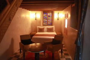 a bedroom with a bed and a table and chairs at Sultana larache in Larache