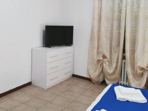 a bedroom with a tv and a dresser with a bed at Flat blue in Verona