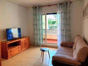 a living room with a couch and a television at Studio Parque Mar in La Mata