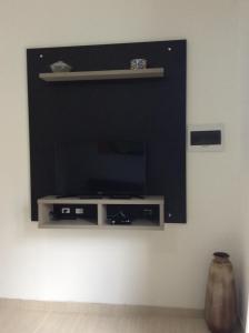 ein Wohnzimmer mit einem TV an der Wand in der Unterkunft RESIDENCIAL ANNABEL APTO 03 in Bombinhas