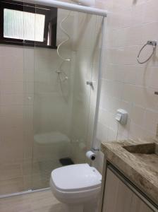 a bathroom with a toilet and a glass shower at RESIDENCIAL ANNABEL APTO 03 in Bombinhas +6 photos