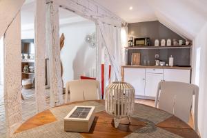 a room with a table and chairs and a kitchen at LE BALDAQUIN / Les Suites Romantiques Honfleur in Honfleur