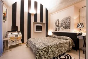 ein Schlafzimmer mit einem Bett und einer schwarz-weiß gestreiften Wand in der Unterkunft Lori's Inn in Mondovì