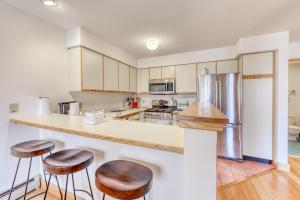 a kitchen with white cabinets and bar stools at The Woods: D4 in Killington